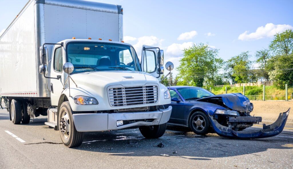 Collision of a semi truck with box trailer a passenger car on the highway road