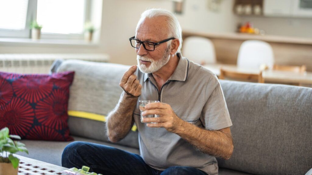 man with glass of water taking pill at home, This investigation involves individuals who may have a claim against drug manufacturers if they took Zantac or ranitidine and later developed certain cancers.