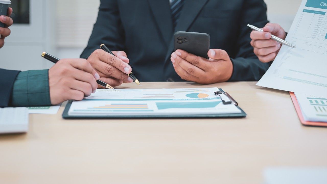 A lawyer meets with expert witness to go over facts, in a professional office.